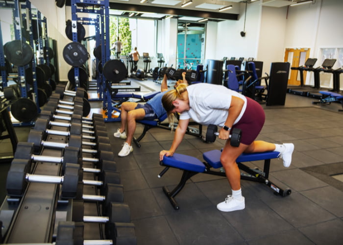 Working out using dumbbells on the benches in the gym