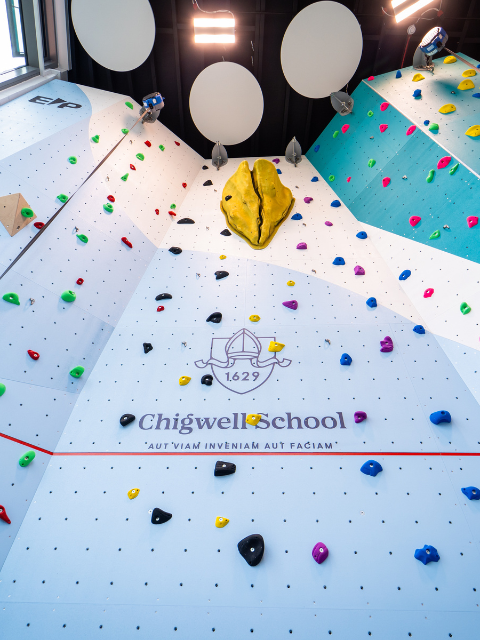The climbing wall at the centre with the Chigwell school logo applied onto the wall